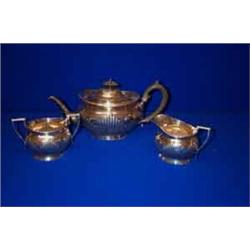 A THREE PIECE TEASET, BIRMINGHAM 1907, of oval form and fluted body, on foot, consisting of teapo...