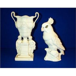 A WHITE STAFFORDSHIRE GROUP, c.1800, of a swagged urn on pedestal flanked by...