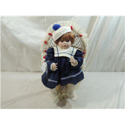 SEATED PORCELAIN DOLL IN WICKER CHAIR