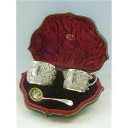 A CASED PRESENTATION CREAM JUG AND SUGAR BASIN, and casting ladle, repousse decorated, gilt inter...