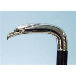 An ebonized mahogany walking stick. Silver handle in form of an eagle's head. With cabochon stone…