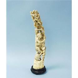 An antique Japanese carved ivory group depicting acrobats with masks performing a climbing act. I…