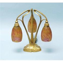 ART NOUVEAU - Daum, Nancy. A fine French gilt bronze table lamp. The triple foliate armed fixture…