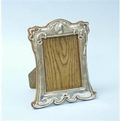ARTS AND CRAFTS - An English sterling silver and oakwood easel picture frame. 8" x 7". Fully mark…