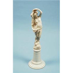 A finely carved antique French vitrine size ivory figure of a young woman bather partly covered w…