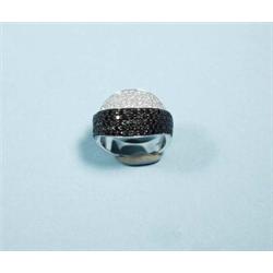 A 14 kt. yelow gold and diamond ring of modernist design. Two overlaping ribbons pave set with bl…