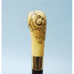 A fine antique English mahogany walking stick. Stained Japanese ivory bun handle carved with figh…