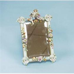 An antique German porcelain framed table mirror. Hand painted with two putti and floral decoratio…