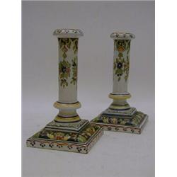 A PAIR OF FAIENCE CANDLESTICKS, classical column shape, square bases, polychrome floral decoratio...