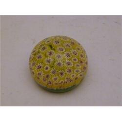 A MILLEFIORE GLASS PAPERWEIGHT, primrose and claret florets on a green ground, height 6cm, diamet...
