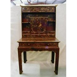 A fine quality Oriental red lacquered writing table with raised back fitted various shelves, cupb...