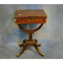 A Regency rosewood and brass inlaid games/work table, the swivel top with hinged lid revealing an...