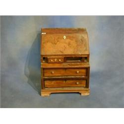 A Georgian style figured walnutwood bureau with fall front revealing a well fitted interior above...