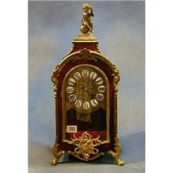 A 19th/20th Century French 8 day striking mantel clock with embossed gilt metal dial and porcelai...