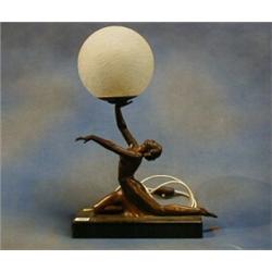 A 1930's Art Deco bronze and marble table lamp in the form of a semi-clad lady supporting a frost...