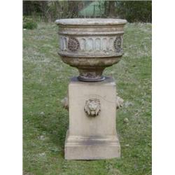 A 19th Century carved stone garden urn with niched and floral decoration, raised on a square base...