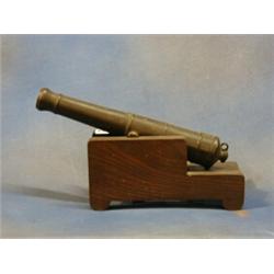 A 19th Century bronze model firing canon 12" raised on a wooden trunion £100-150...