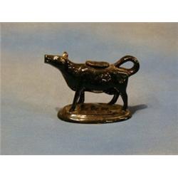 A 19th Century black glazed pottery cow creamer £20-30...