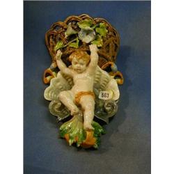 A Majolica wall pocket in the form of a basket supported by a cherub 14" £140-180...