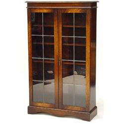 Oak bookcase, fitted a pair of leaded glazed doors enclosing four shelves on a plinth base…