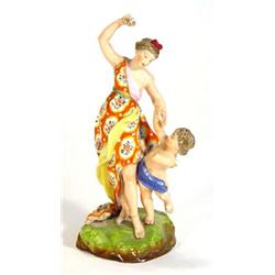 Hand painted and gilded Derby figure group, a young lady in a flowing orange dress beside a cheru…