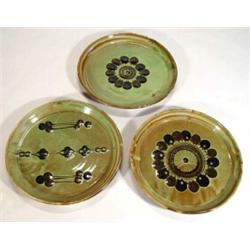 Three Sidney Tustin Winchcombe pottery plates, decorated with green and brown slip glazes, impres…