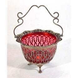 Pierced silver plated basket with swing handle and cranberry glass liner, 18cm high…