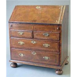 A George II walnut and burr yew crossbanded bureau, with slant enclosing a stepped interior, well...