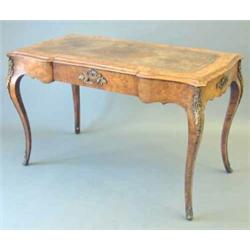 A Victorian inlaid figured walnut writing table, with leather skiver over a frieze drawer on cabr...