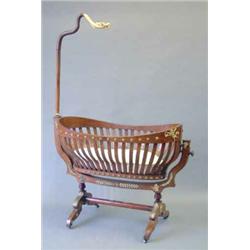 An early 20th century French ormolu mounted mahogany cradle, in the Empire style with a slatted b...