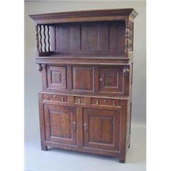 An early 18th century oak tridarn, with overhung moulded cornice on turned baluster supports with...