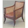 Image 1 : A Regency mahogany bergere chair, with caned back, sides and seat with reeded frame and buttoned...
