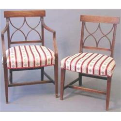 A set of four George III mahogany dining chairs, (including one with arms), with lattice backs on...