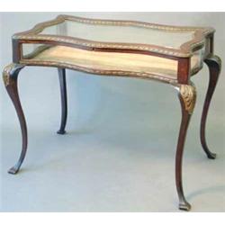 An early 20th century mahogany and parcel gilt bijouterie table, with serpentine sides and bevell...