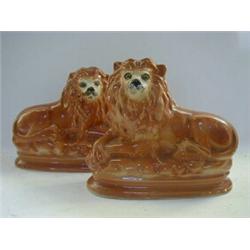 A PAIR OF RECUMBENT LION FIGURES, early 20th Century, inset glass eyes, height 26cm, (firing dama...