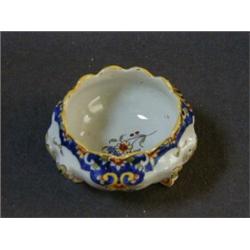 A SMALL FAIENCE POT, 20th Century, wavy rim, polychrome floral decoration, on three scrollwork fe...
