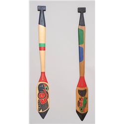 Two Carved and Painted Northwest Coast Paddles by Laurence Andrew; Raven 47 1/2" L. 5 3/4" W. and Sa