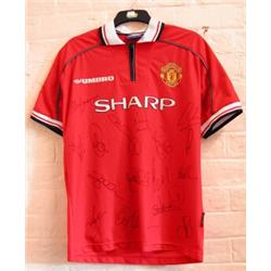 A rare Manchester United home shirt signed by members of the squad at...