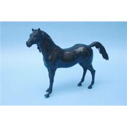 A bronze model of a stallion, depicted standing with raised tail, nostrils flaring (some damage t...