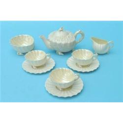 A Belleek shell-moulded part tea service, comprising:- teapot, sugar bowl, slop bowl, three cups...
