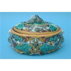 A Wedgwood majolica oval tureen, moulded with game, swags of flowers and winged mythical beasts,...