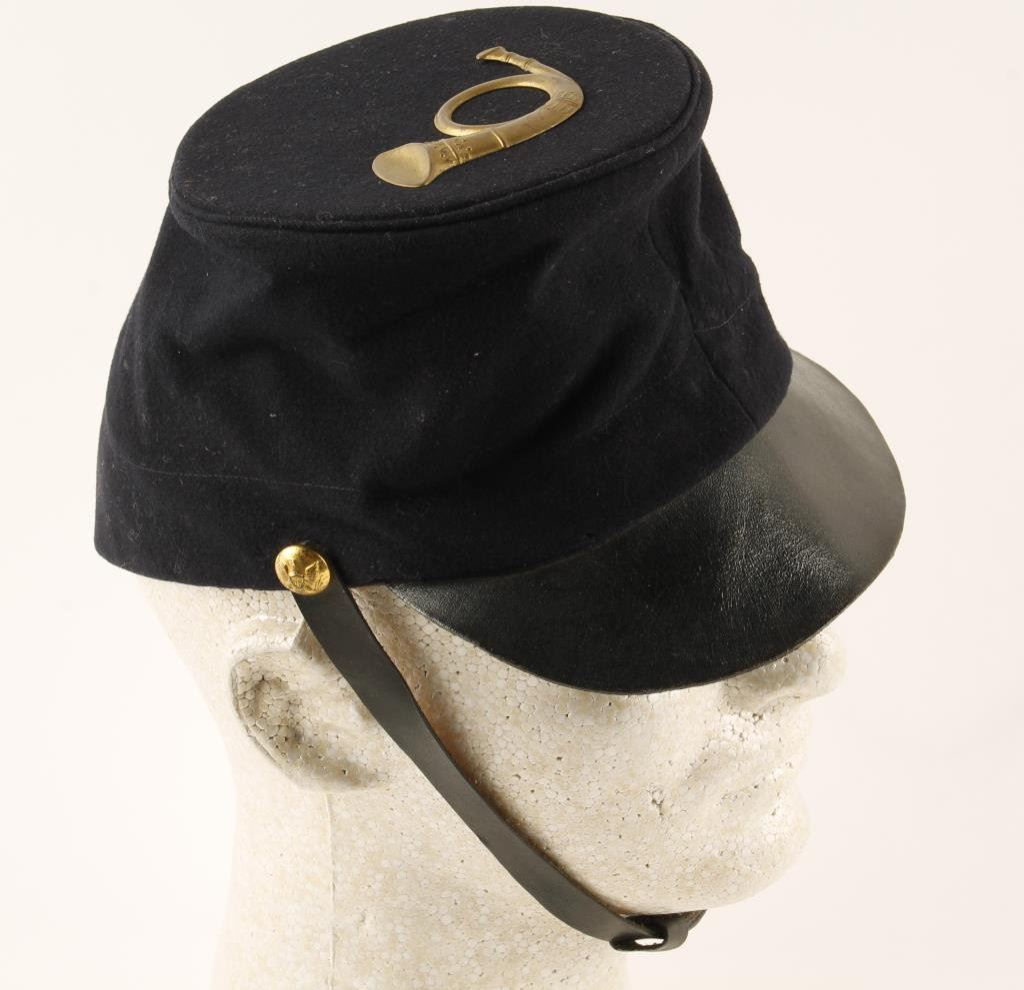 U.S. military kepi cap with leather brim, strap and brass horn emblem in o