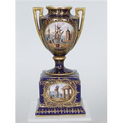 Ziervase. Klassizistische Vase auf würfelförmigen Podest. Kobaltblauer Fond. Auf ausgesparten, v...