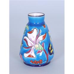 Vase. Steingut. Konisch ansteigende Wandung, kurzer Hals. Auf blauem Fond farbig bemalter Relief...