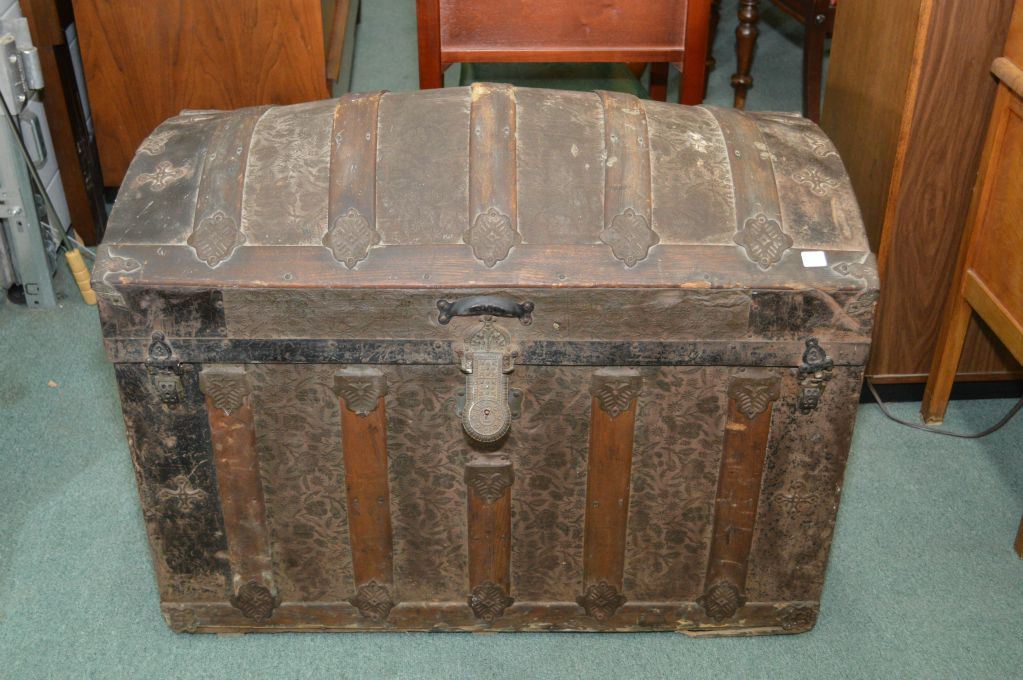 Antique dome top steamer trunk with oak and metal binding and decorative metal sheet panels
