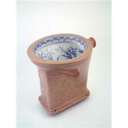 A late Victorian water closet, with brown stoneware exterior moulded with flowers and transfer pr...