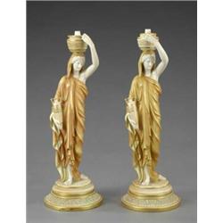 A pair of Royal Worcester matt ivory figures of lamp bearers,...