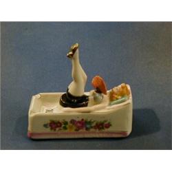 A 1930's Japanese pottery "nodding" ashtray in the form of a reclining lady £20-30...