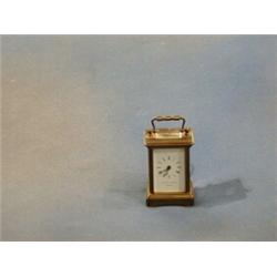 A Swiss 8 day miniature carriage timepiece with enamelled dial and Roman numerals contained in a...