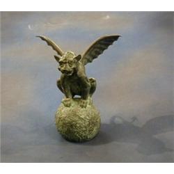 A bronze figure of a winged mythical beast sat on a globe 13" £50-75...